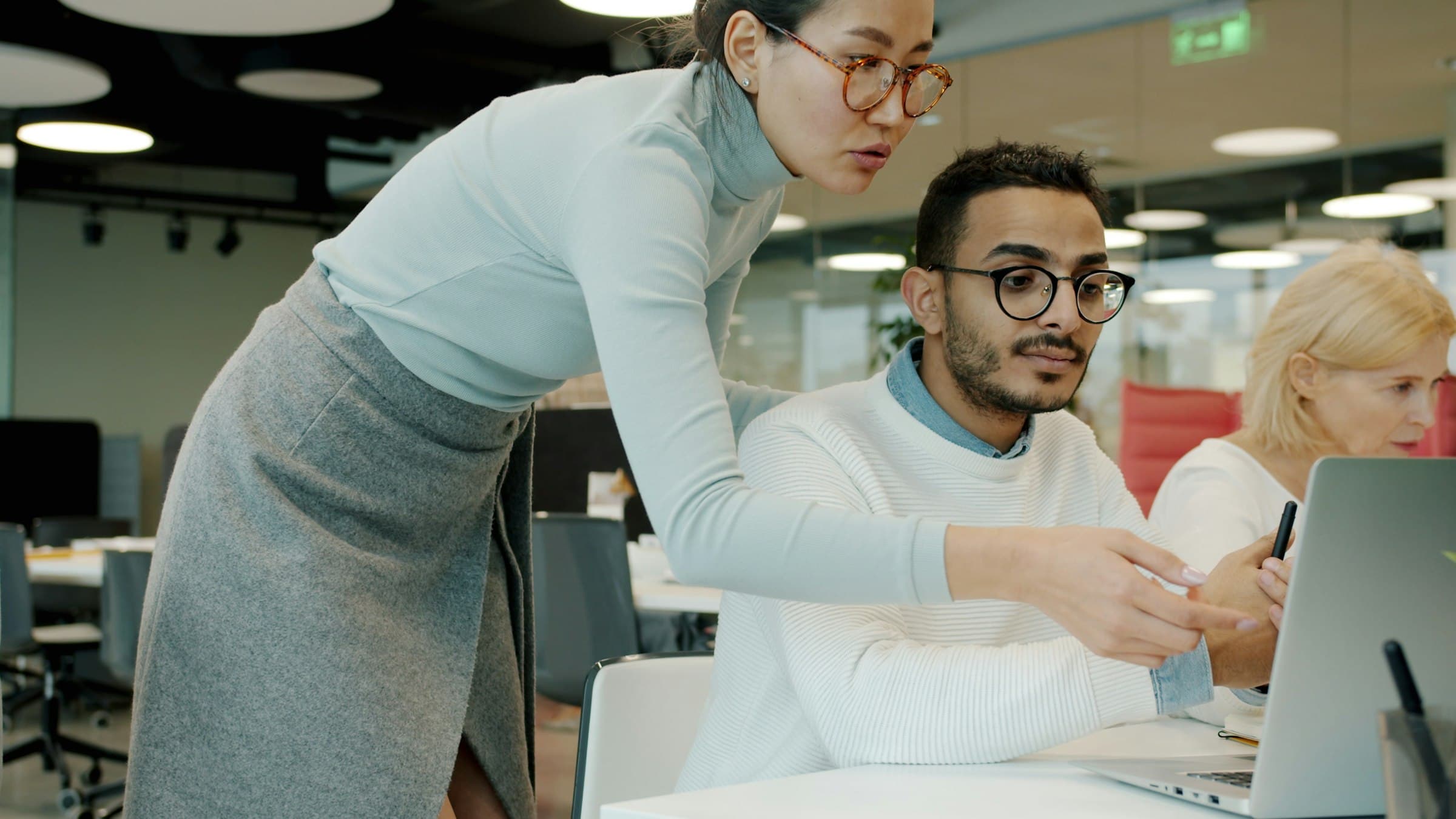 Small team collaborating over a laptop in a bright workspace — clean SaaS tools for founders and growing businesses